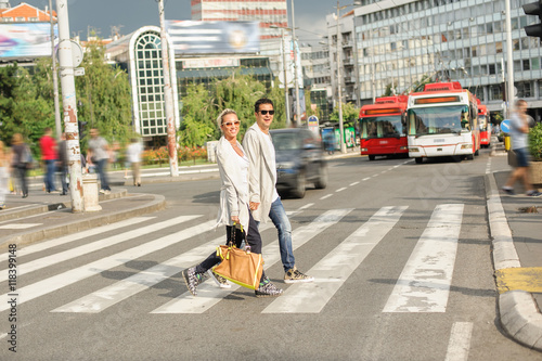 Fashionable couple crossing road at pedestrian zebra crossing © guruXOX