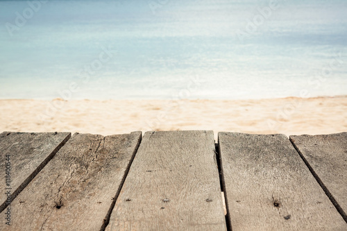 Wooden surface at tropical beach with blurred sea and sandy beach on background