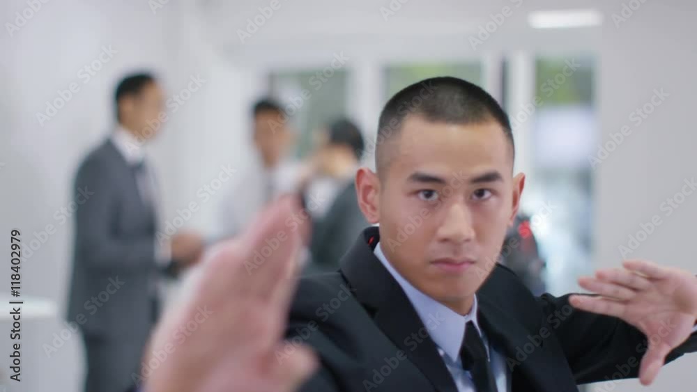 Portrait of serious Asian businessman in martial arts stance Portrait of serious Asian businessman in martial arts stance