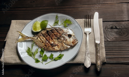 Grilled fish (Vomer) lime ,dill,parsley on the white plate with