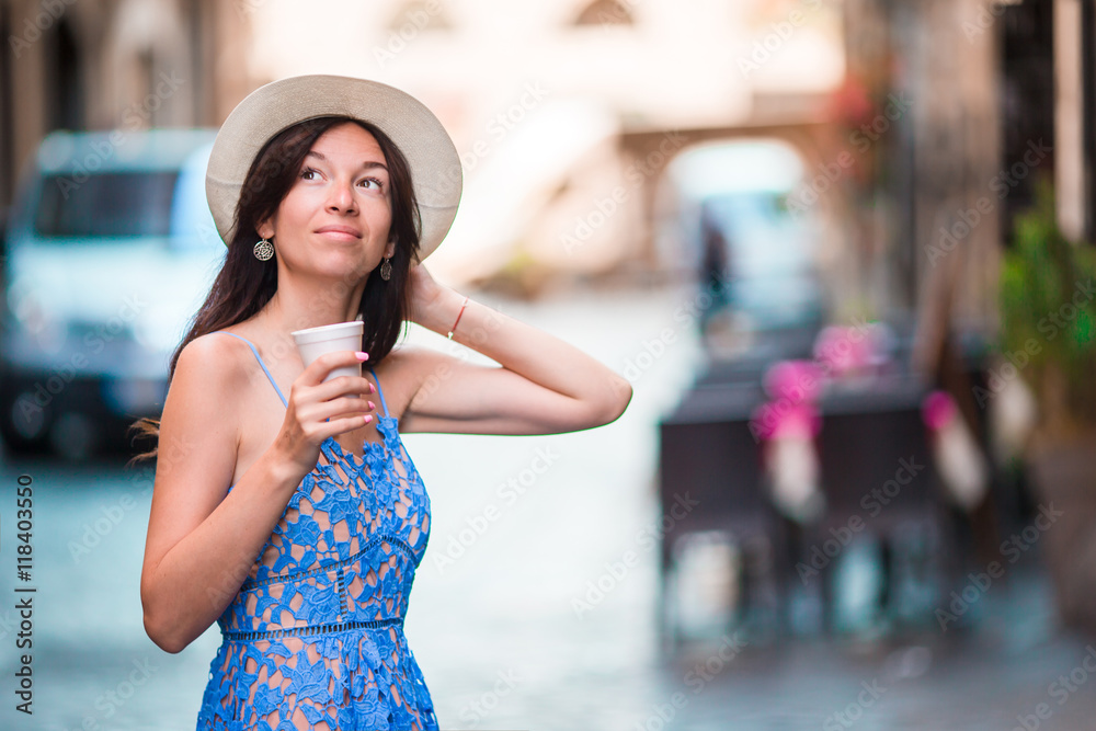 Woman in Rome with coffee to go on vacation travel. Smiling happy caucasian girl having fun laughing on Italian sidewalk cafe during holidays in Rome, Italy, Europe.