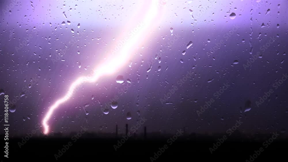 Strong thunderstorm with the rain over a city through window glass.