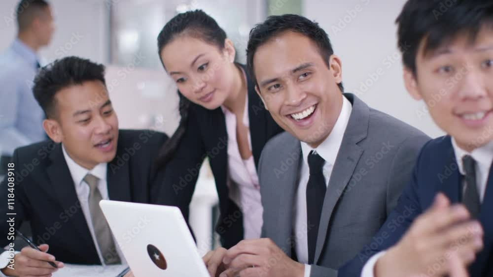 Asian corporate business group looking at computer in a meeting start clappin Asian corporate business group looking at computer in a meeting start clappin