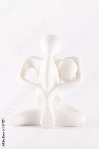 фигурка из камня сидит в позе йога