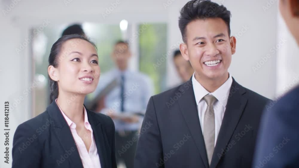 Smiling Asian business group shake hands & discuss business Smiling Asian business group shake hands & discuss business