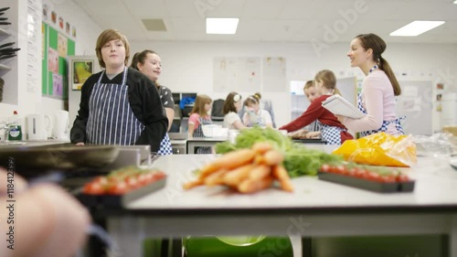  Teacher teaching pupils in school cookery class photo