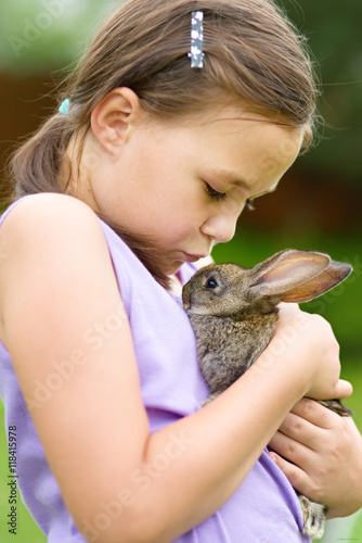 Girl is holding a little rabbit