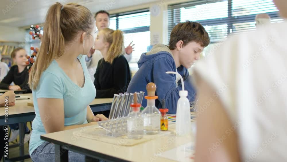 Teacher teaching group of students in school science class Teacher teaching group of students in school science class