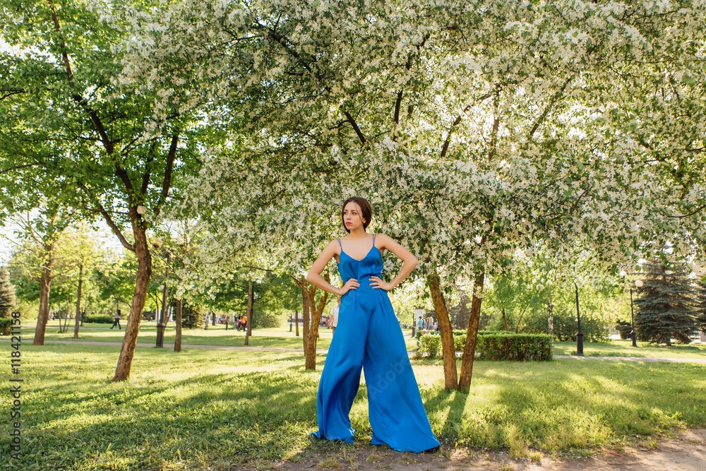 Fototapeta premium Beautiful young woman standing near the apple tree.