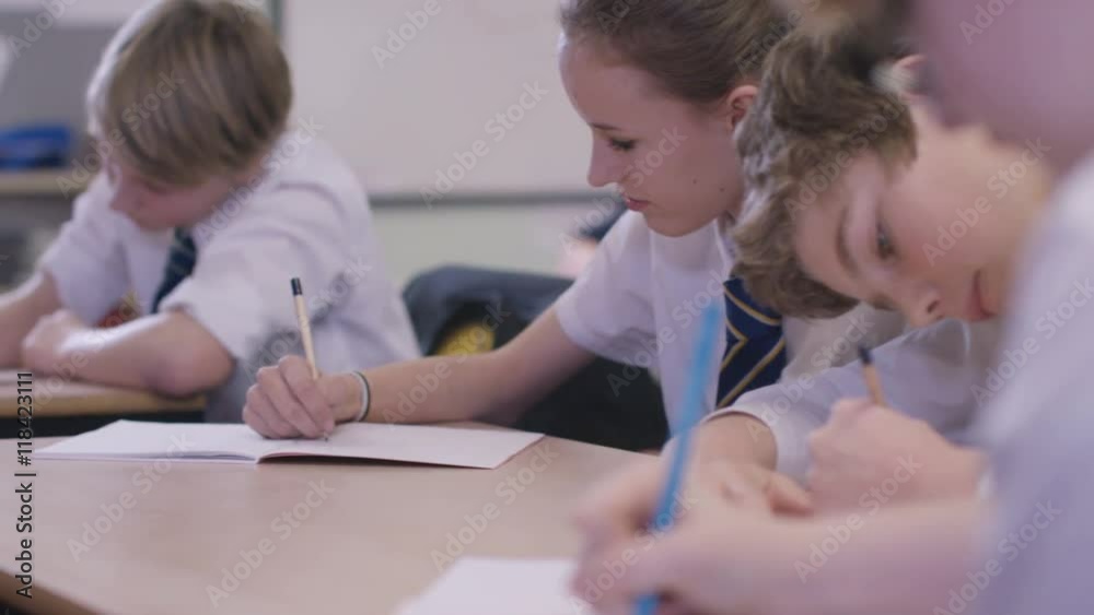Young students working at their desks in school classroom Young students working at their desks in school classroom