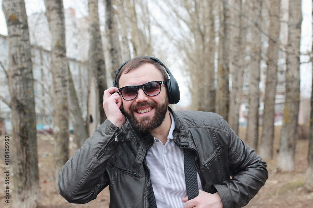 man with beard and headphones in the park
