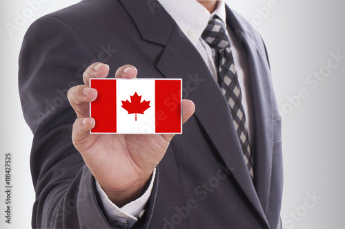 Businessman in suit holding a business card with a Canada Flag
