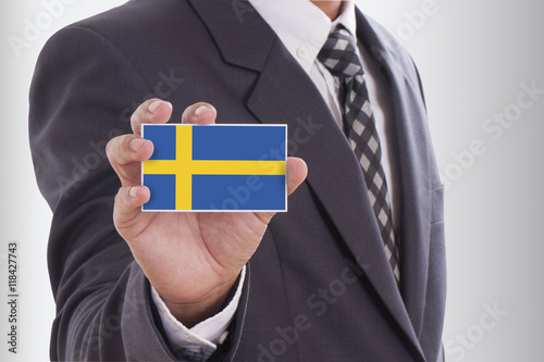 Businessman in suit holding a business card with Sweden Flag