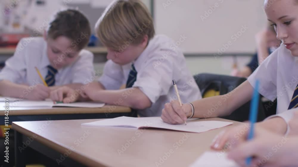 Young students working at their desks in school classroom Young students working at their desks in school classroom