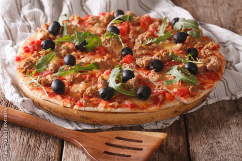 Fish Pizza with tuna, olives and arugula close-up. horizontal 