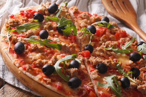 Hot pizza with tuna, olives and arugula close-up. horizontal 