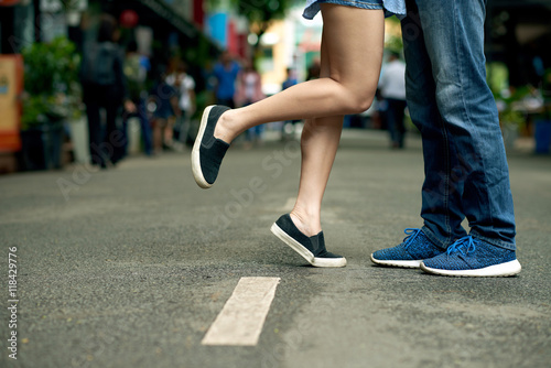 Legs of young couple kissing in the street