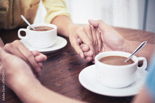 Hands of couple having date in cafe