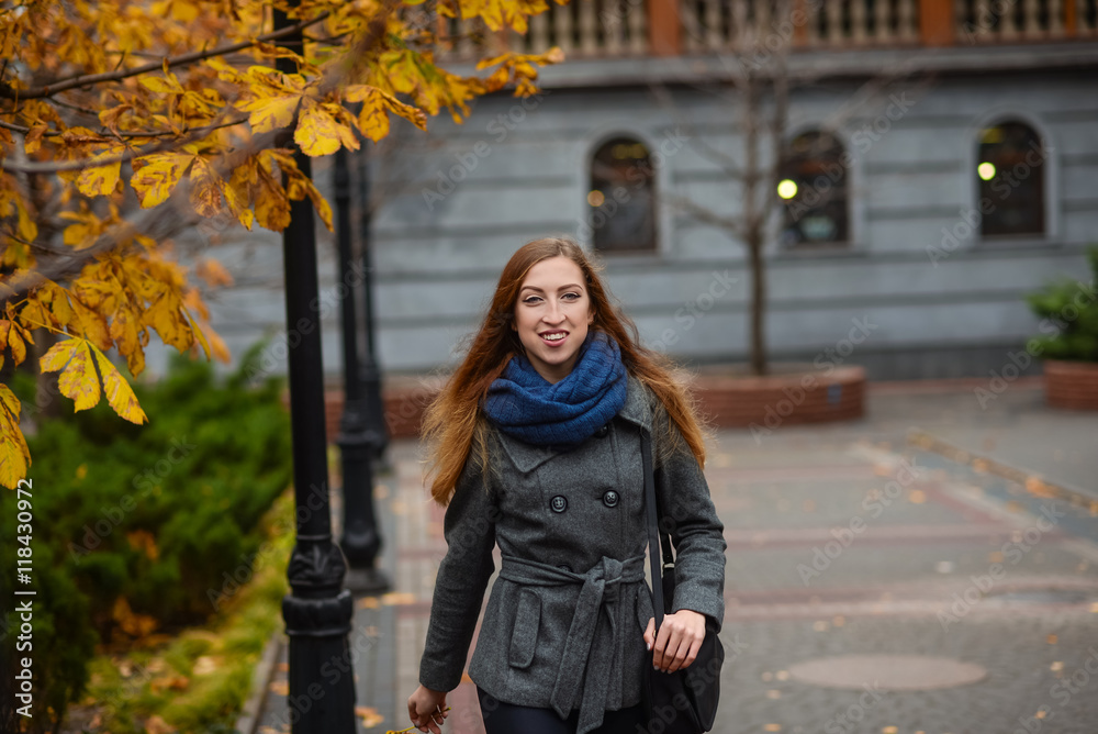 Young woman has a walk in autumn city park