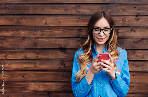 Beautiful young hipster woman using smart phone