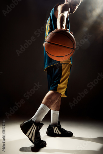 Silhouette view of a basketball player holding basket ball on black background © master1305