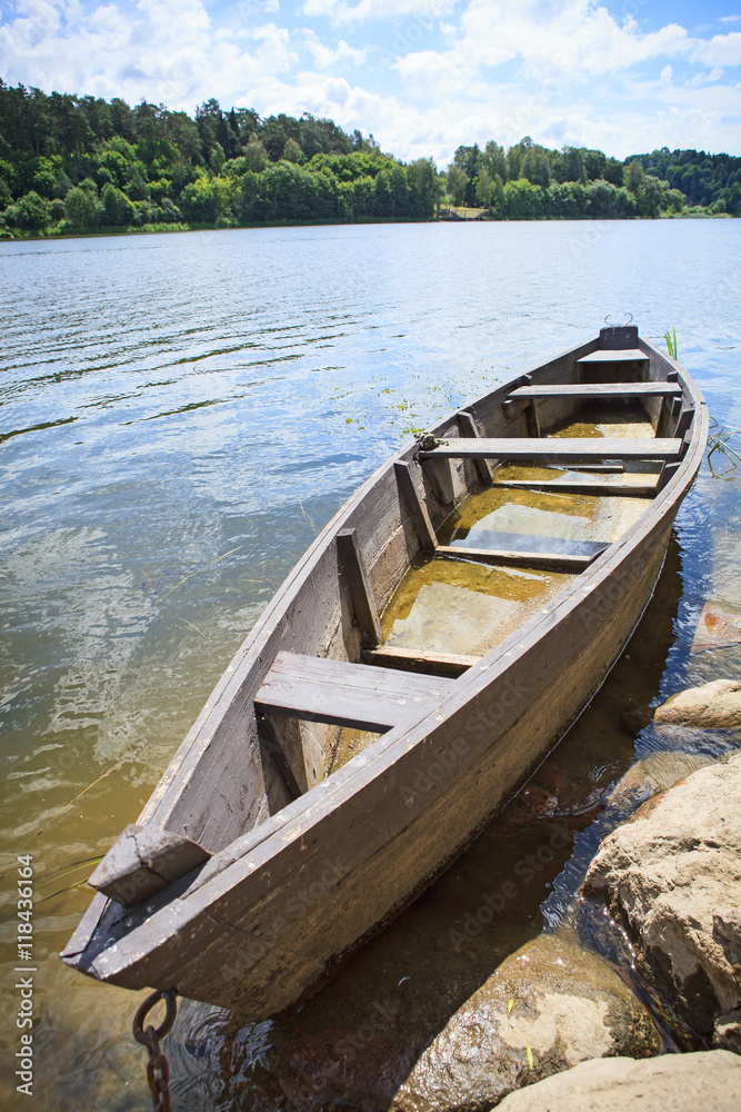 Wooden rowing boat on lake shore