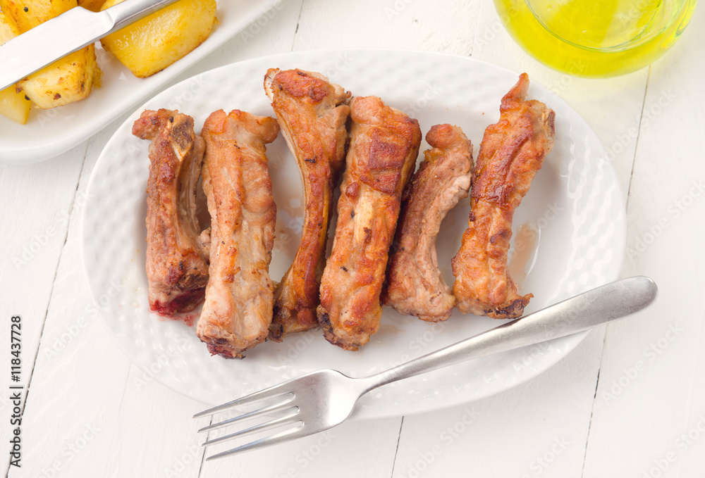 overhead take fried pork ribs in white tray on wooden