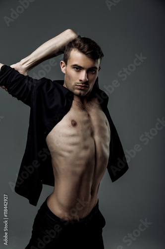 sexy young fashion man wearing a black shirt unbuttoned