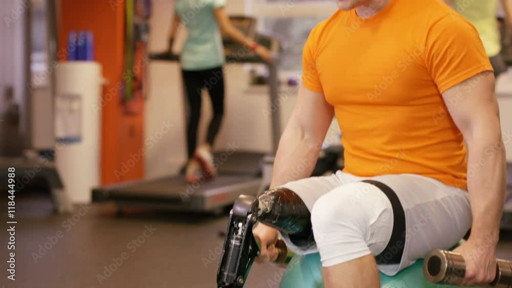 Muscular man with prosthetic leg working out with weights at the gym Muscular man with prosthetic leg working out with weights at the gym