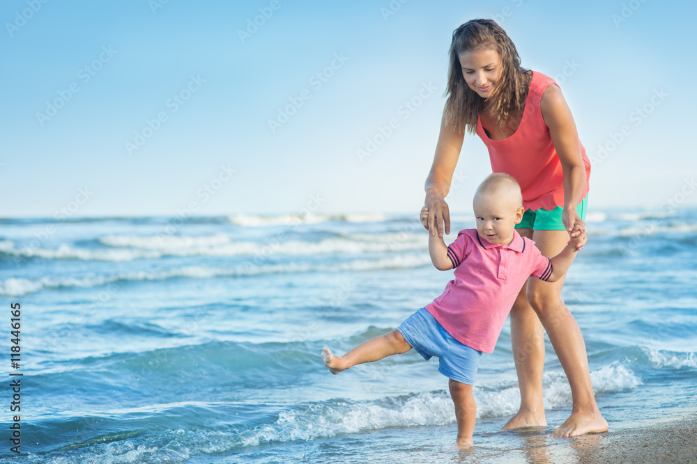 woman with a child playing on the beach woman with a child playing on the beach