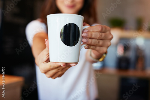 Closeup of waitress giving coffee in the mug