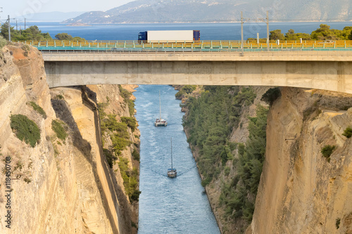 Quadro em tela Large truck traversing the bridge of isthmus of Corinth in Greece while the boats are travelling in the bottom