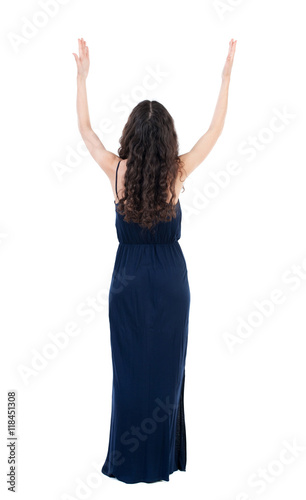 Back view of beautiful woman welcomes. Young teenager girl in jeans hand waving from. Rear view people collection. backside view of person. Isolated over white background. The dark curly girl in