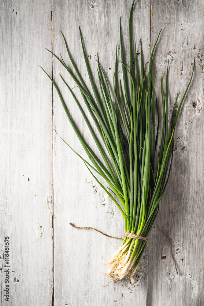 Green onion on the white wooden table top view Green onion on the white wooden table top view
