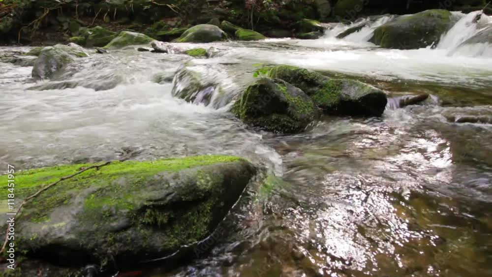 small cascades of the brook among huge boulders covered with moss. beautiful nature scenery small cascades of the brook among huge boulders covered with moss. beautiful nature scenery