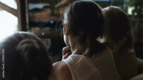 Group of happy kids watching tv at home, view from behind