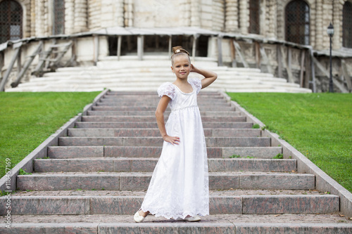 Portrait of a beautiful young little girl in white gown photo