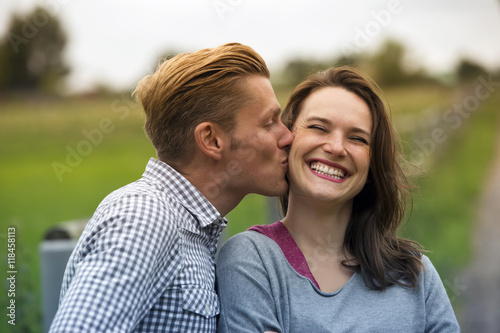 man kissing woman on her cheek