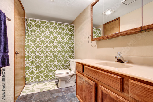 Bathroom interior with vanity  tile floor and green shower curtain.