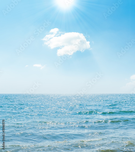 sun in blue sky over sea