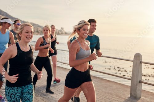 Young people running along a seaside promenade