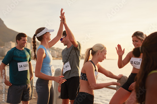 Fototapeta Naklejka Na Ścianę i Meble -  Athletes high fiving after a race