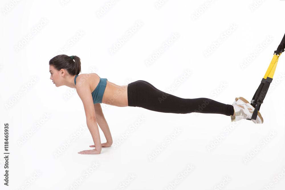 Core body excercise concept. Woman exercising with suspension straps isolated on white background. Studio shot. Core body excercise concept. Woman exercising with suspension straps isolated on white background. Studio shot.