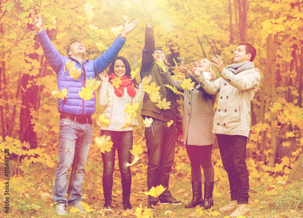 Naklejka premium group of smiling men and women in autumn park