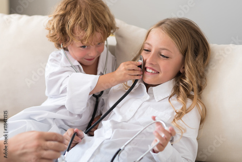 Cheerful boy putting stethoscope on cheek