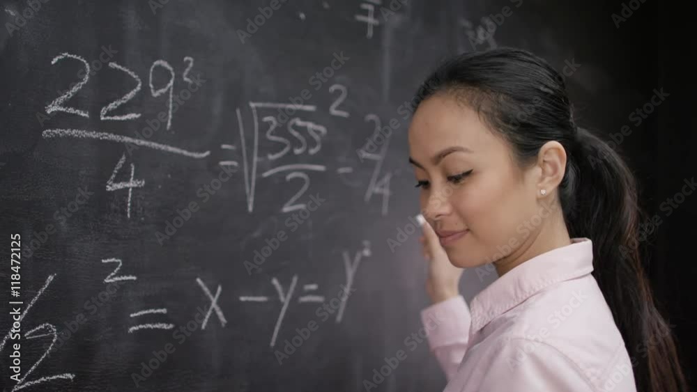 Attractive teacher or academic writing math formulas on blackboard. Attractive teacher or academic writing math formulas on blackboard.