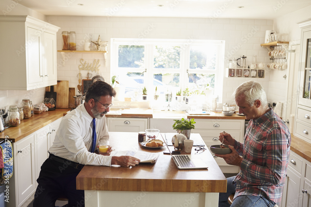 Male couple sitting at kitchen island before work, close up Male couple sitting at kitchen island before work, close up