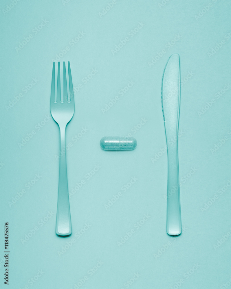 Eating pills / Creative still life of fork and knife at a lunchtime with a pill served. Eating pills / Creative still life of fork and knife at a lunchtime with a pill served.