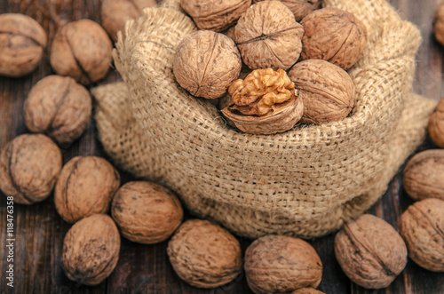 Walnuts on a bag, wooden background