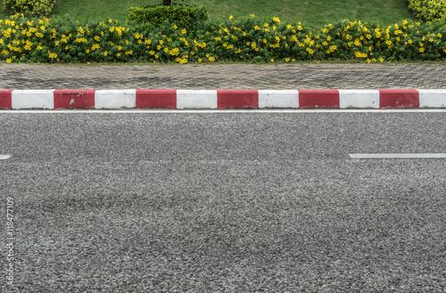 Asphalt road with red and white concrete curb